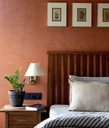 terra cotta walls in bedroom with brown wood furniture