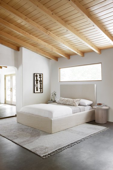 minimalist bedroom with geometric rug under bed