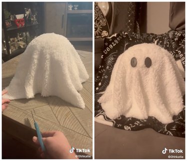 On the left is a white sherpa blanket laying over a plush animal. On the right is a fluffy ghost pillow with two black button eyes.