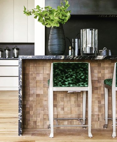 Black, white and green kitchen with tonal wood and black kitchen island