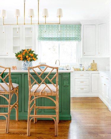 White kitchen with bright green island and tangerine centerpiece