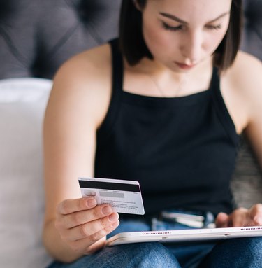 woman holding credit card and ipad
