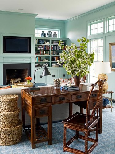 mint green living room with wood desk