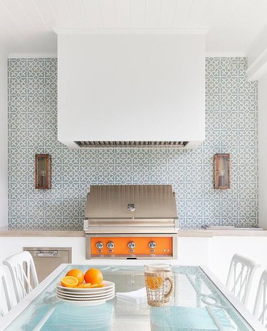 coastal outdoor kitchen with blue and white tile and orange bbq