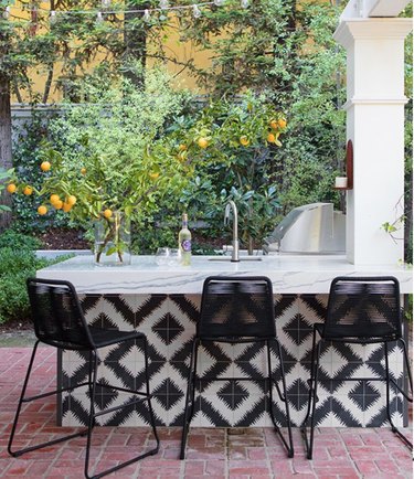 bar area around an outdoor kitchen that features black and white tile