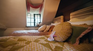 A bedroom with two twin beds and a small window