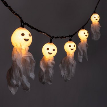A string of lights that look like adorable ghosts. The lights are in the ghosts' heads and they are smiling.