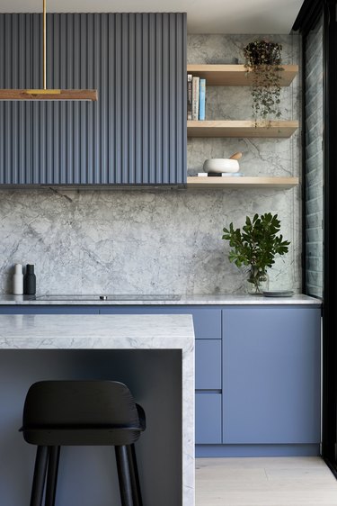 blue reeded cabinets in modern kitchen with marble backsplash