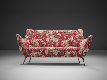 red floral sofa with mid-century silhouette