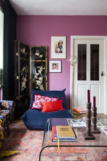 Purple living room with blue chair and red pillows.