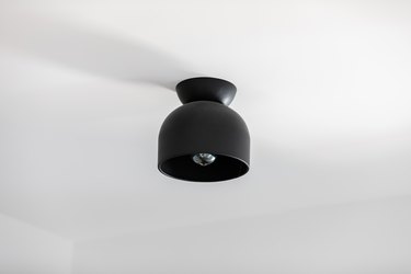 Black lighting fixture on a white ceiling