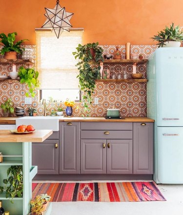 orange kitchen with ice blue fridge and gray cabinets