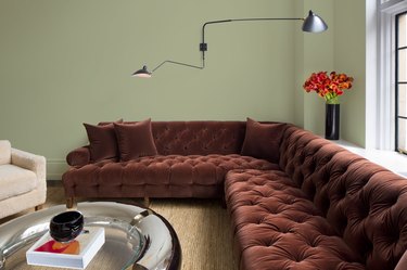 living room with large sectional couch and green wall