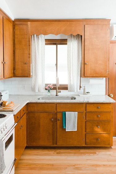 white granite countertop in midcentury kitchen with warm wood cabinets
