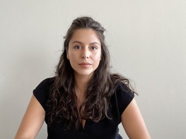 person with wavy long black hair and a black shirt