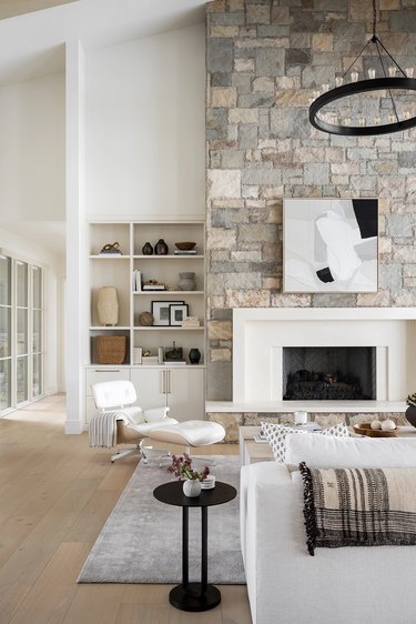 White chair and couch, stone wood fireplace in Utah cabin