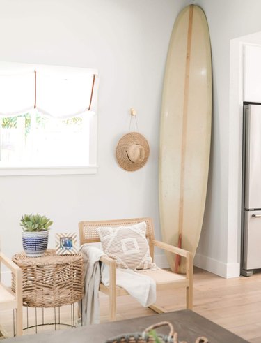 Neutral colored living room with surfboard in corner