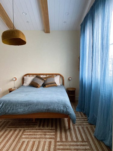bedroom with beige walls and light blue curtains