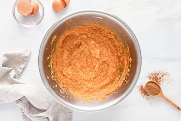 A bowl filled with an orange mixture of the wet ingredients.