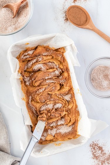 A knife swirling the cinnamon-sugar mixture into the orange batter.