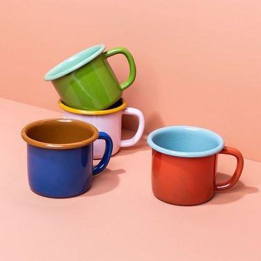 Four enamel mugs featuring the following color pairings: green/light blue, red/light blue, dark blue/dark orange, and pink/yellow.