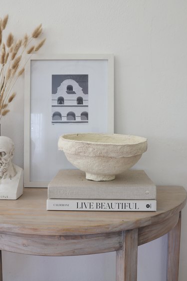 DIY paper mache bowl on top of books styled on a table