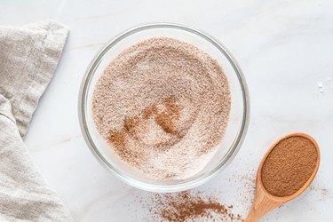 A glass bowl filled with a mixture of sugar and cinnamon.