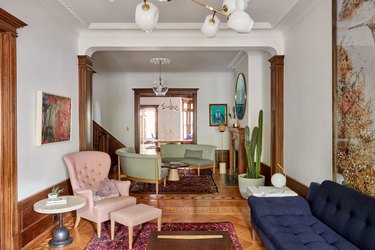 seating area in historic brownstone that features pink, blue and sage green furniture