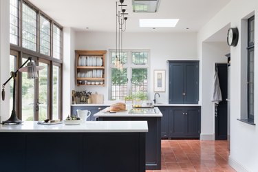 kitchen with navy blue cabinets and saltillo tile floors