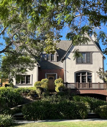 A traditional home with greige siding and red brick front