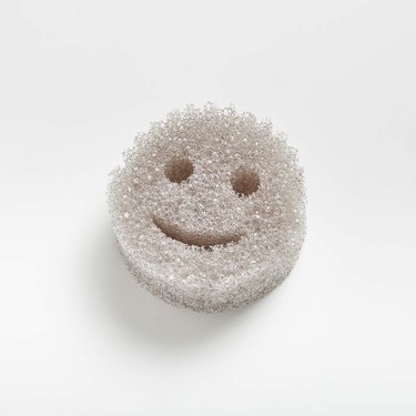 A grey Scrub Daddy smiley face sponge on a white background.