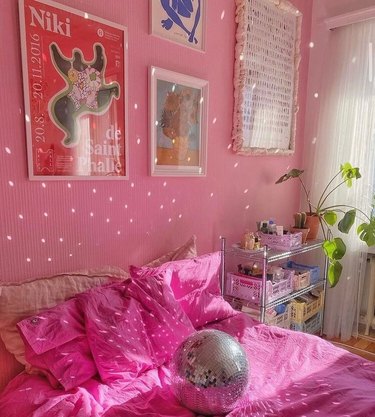 pink bedroom with disco ball on bed, throwing light on walls