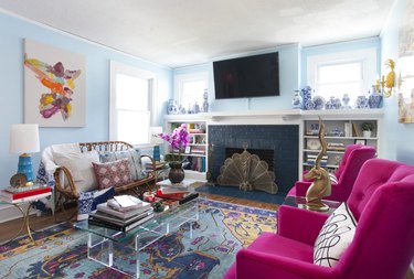 Light blue room with fuchsia chairs and rugs.