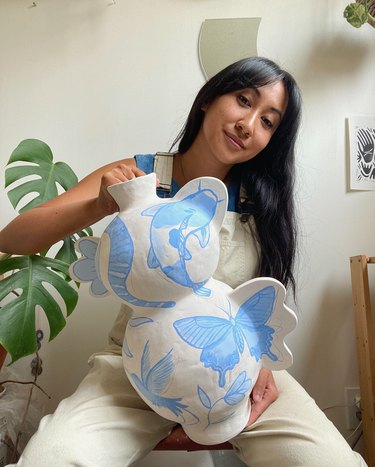 Lauren Strybos holding large white clay vase