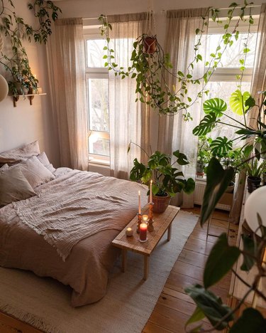 bedroom with arrangement of lit candles on table at foot of bed