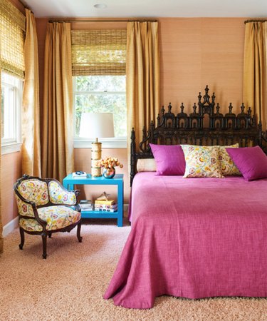 bedroom with fuchsia bedding, yellow walls and blue side table