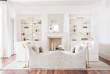 all white french country living room with built in shelves