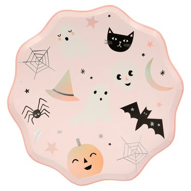 A light pink dinner place with wavy edges. On the plate, there are cute cartoon black cats, ghosts, a bat, spiderwebs, a witch hat, a skull, a spider, a moon, and small stars in pink, black, and silver.