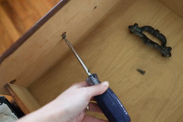 Removing the drawer handle screws with a screwdriver