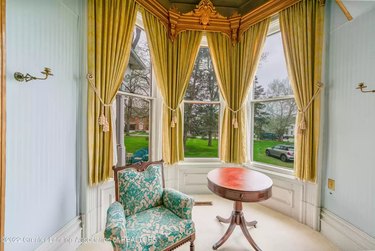 Sun room with gold curtains and blue chair