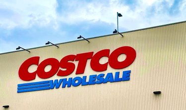Image of costco logo on a storefront in front of a blue sky