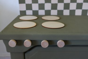 Four wood knobs glued underneath the four wood circles to create stove knobs