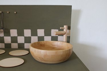 Wood faucet and wood bowl glued on top of nightstand to create a sink area