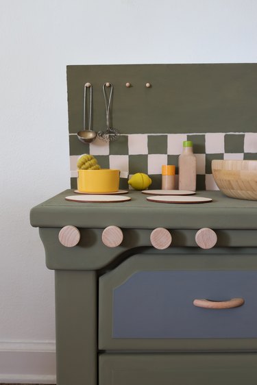DIY olive green kids play kitchen with checkerboard backsplash and blonde wood accents