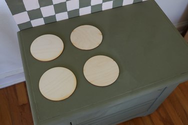 Four wood circles glued to the top of the nightstand to create stove burners