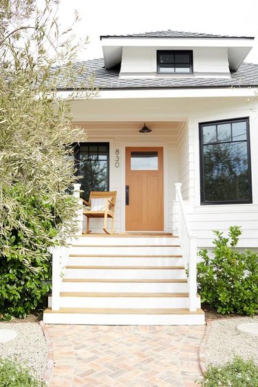 black and white home with natural wood door