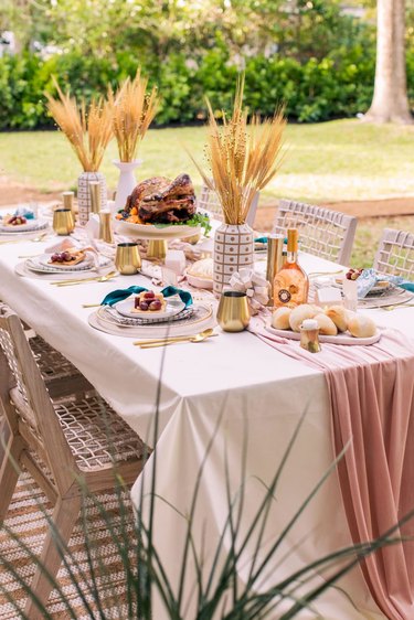 table with pastel linens and vases filled with wheat