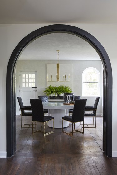 dining room with modern black and gold chairs and ivory walls