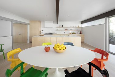 interior of a home with kitchen area, white table and colorful chairs