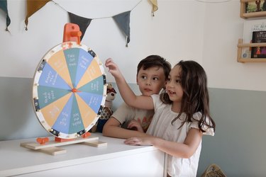 Two kids spinning IKEA activity chore prize wheel